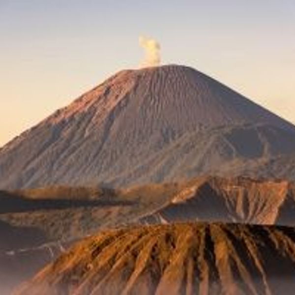 Voyage en Asie — Volcans Bromo et Semeru à Java, Indonésie : panorama au lever ou coucher du soleil avec crêtes volcaniques et fumée au sommet.