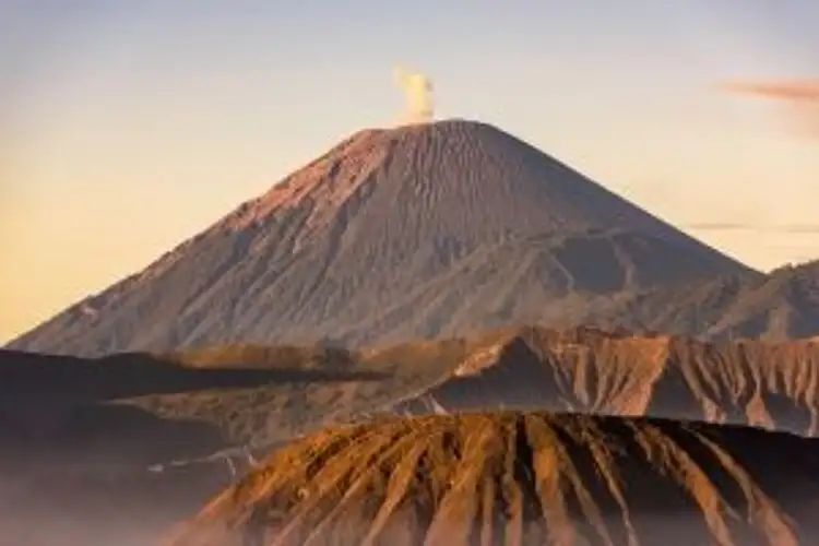 Voyage en Asie — Volcans Bromo et Semeru à Java, Indonésie : panorama au lever ou coucher du soleil avec crêtes volcaniques et fumée au sommet.