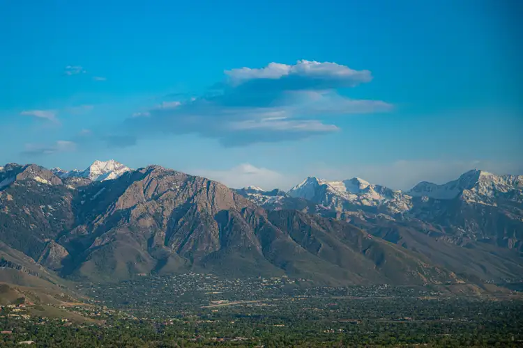 Chaîne des montagnes Wasatch aux sommets enneigés dominant la vallée sous un ciel bleu nuageux à Salt Lake City