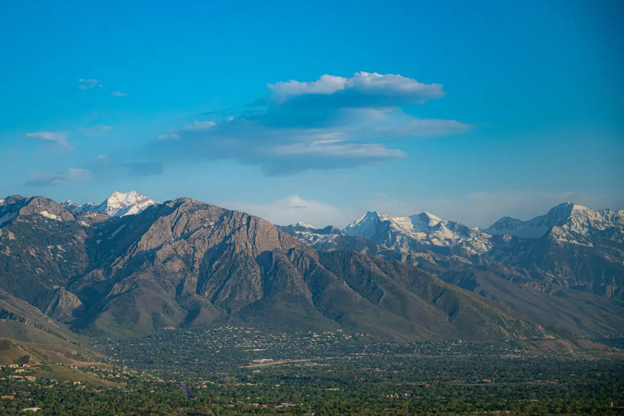 Chaîne des montagnes Wasatch aux sommets enneigés dominant la vallée sous un ciel bleu nuageux à Salt Lake City