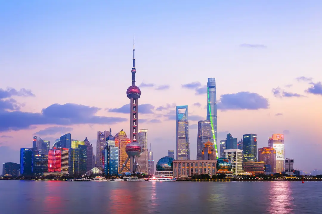 Vue panoramique iconique de la skyline de Shanghai avec la tour de la Perle de l'Orient illuminée au crépuscule depuis le Bund.