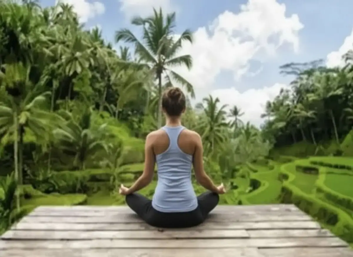 Voyage en Asie — Femme méditant dans les rizières en terrasses à Bali : calme, connexion à la nature et paysage verdoyant.