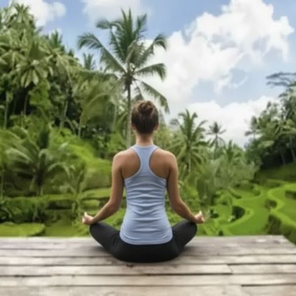 Voyage en Asie — Femme méditant dans les rizières en terrasses à Bali : calme, connexion à la nature et paysage verdoyant.