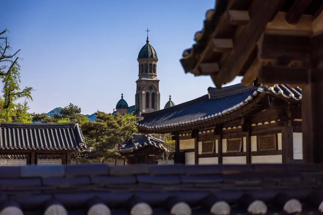 Voyage en Corée du Sud - Temple et cathédrale de Jeonju Hanok Village, avec maisons traditionnelles en bois, où l’on découvre le charme des toits ondulés.