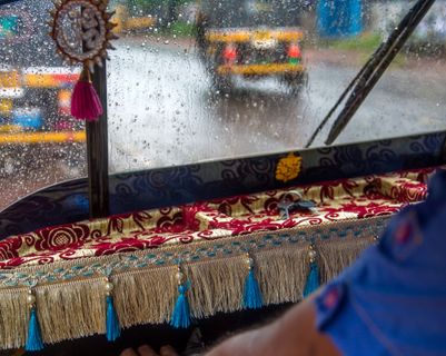 Voyage en Asie – Tuk-tuk décoré en Inde sous la pluie, symbole de voyage authentique pendant la mousson