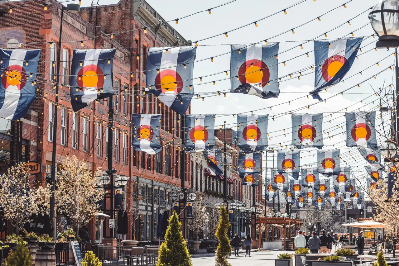 Rue historique de Larimer Square à Denver pavée et décorée de drapeaux du Colorado suspendus entre des bâtiments en briques
