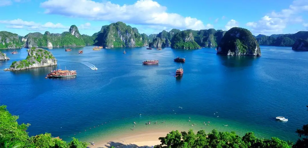 Voyage Vietnam : vue panoramique sur la plage et les jonques dans la baie d'Ha Long