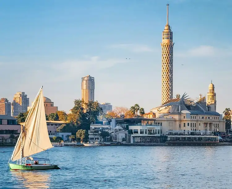 Felouque naviguant sur le Nil devant la Tour du Caire au coucher du soleil