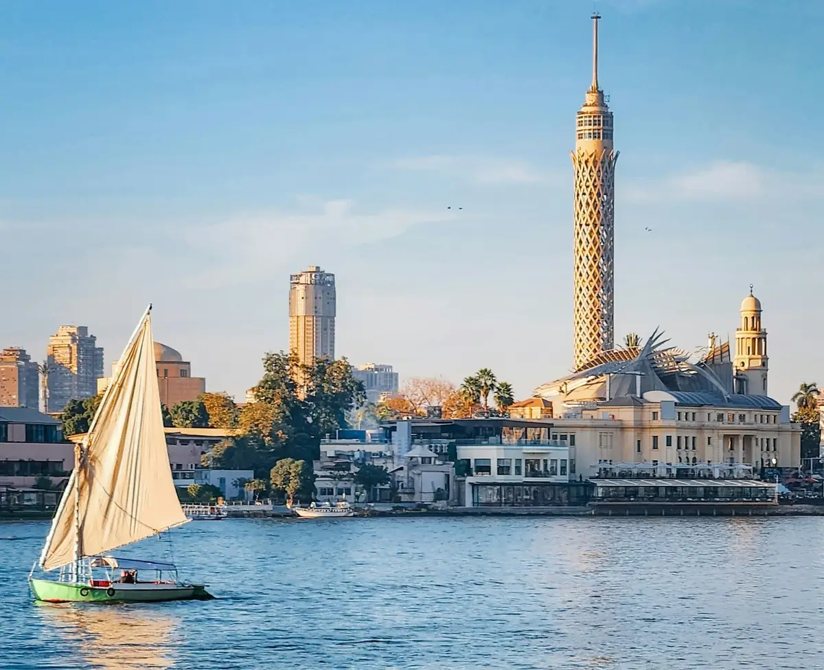 Felouque naviguant sur le Nil devant la Tour du Caire au coucher du soleil