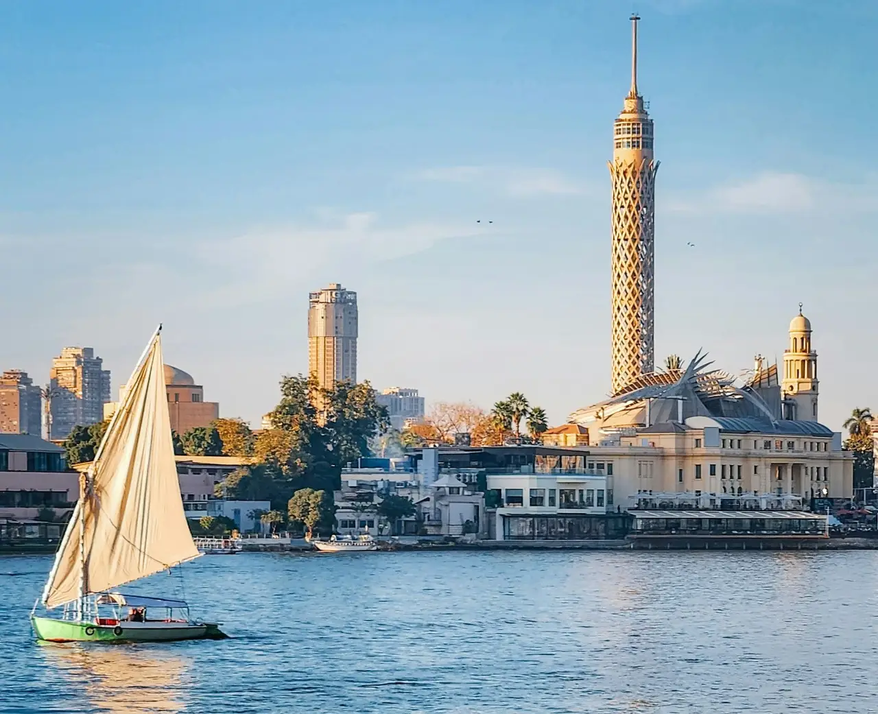 Felouque naviguant sur le Nil devant la Tour du Caire au coucher du soleil