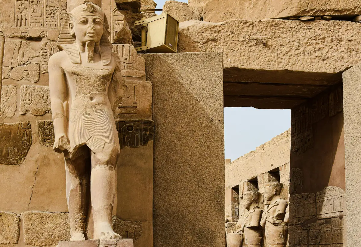 Statue de pharaon à l'entrée d'une porte monumentale au temple de Karnak