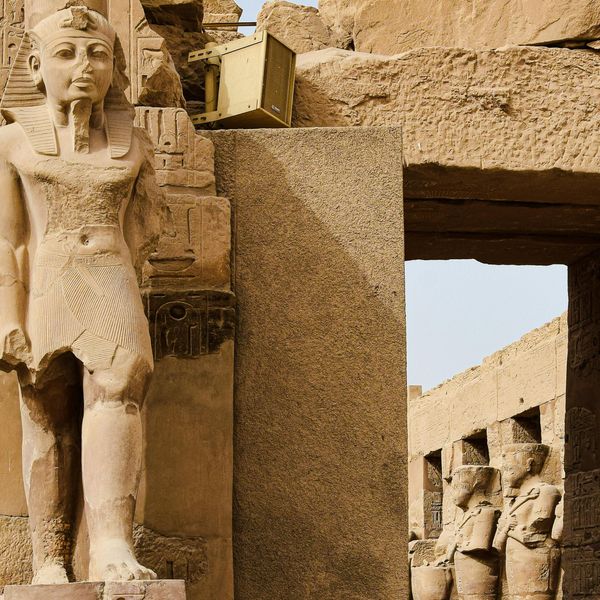 Statue de pharaon à l'entrée d'une porte monumentale au temple de Karnak