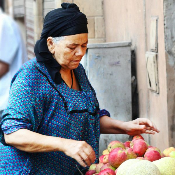 Une femme égyptienne choisit des fruits sur un étal au marché