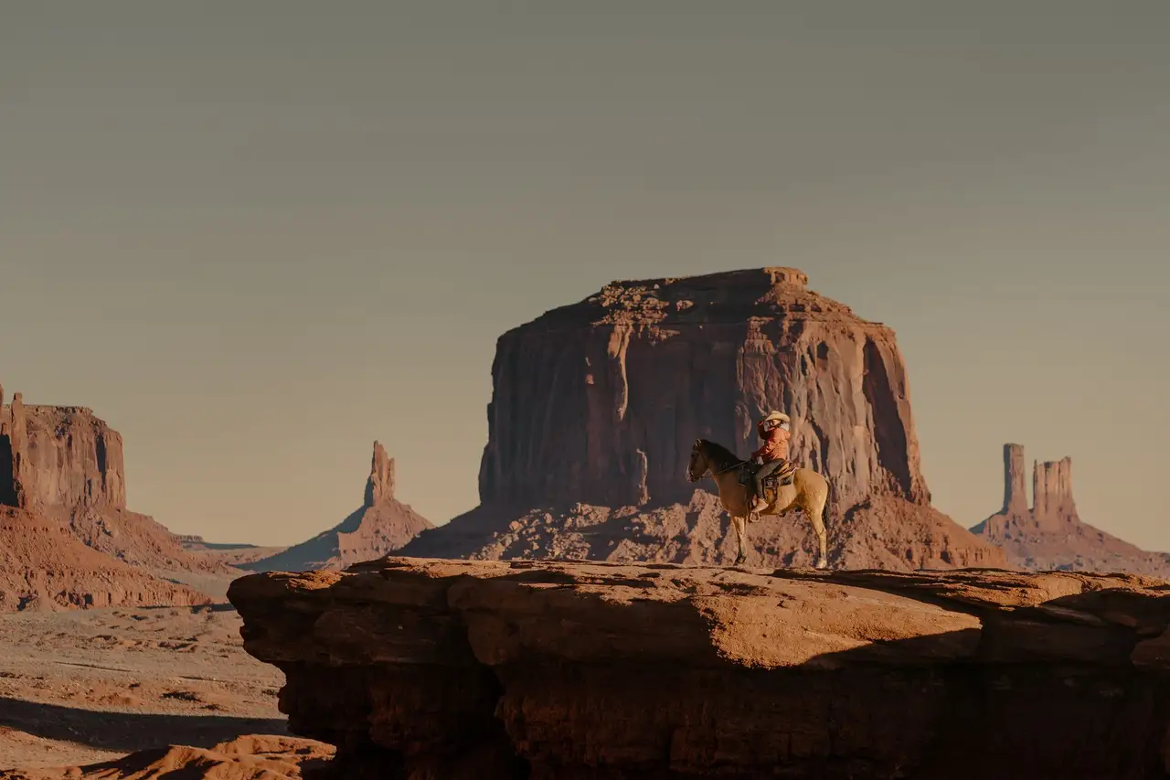 Enfant sur un cheval dans le décor de Monument Valley aux Etats-Unis