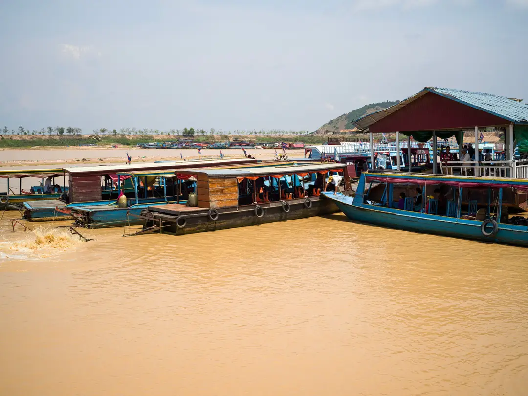 les bateaux en bois colorés amarrés le long d'une rive vibrante