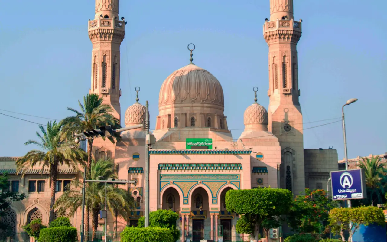 Façade d'une mosquée et son dôme central sous un ciel clair