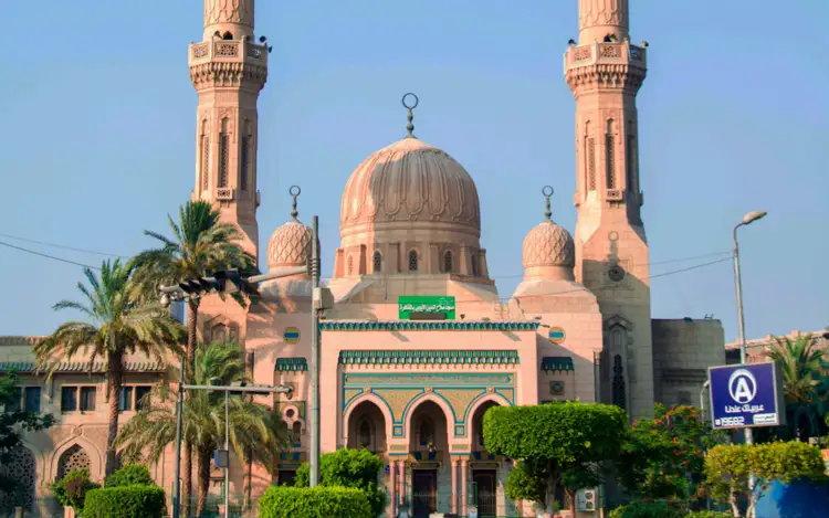 Façade d'une mosquée et son dôme central sous un ciel clair