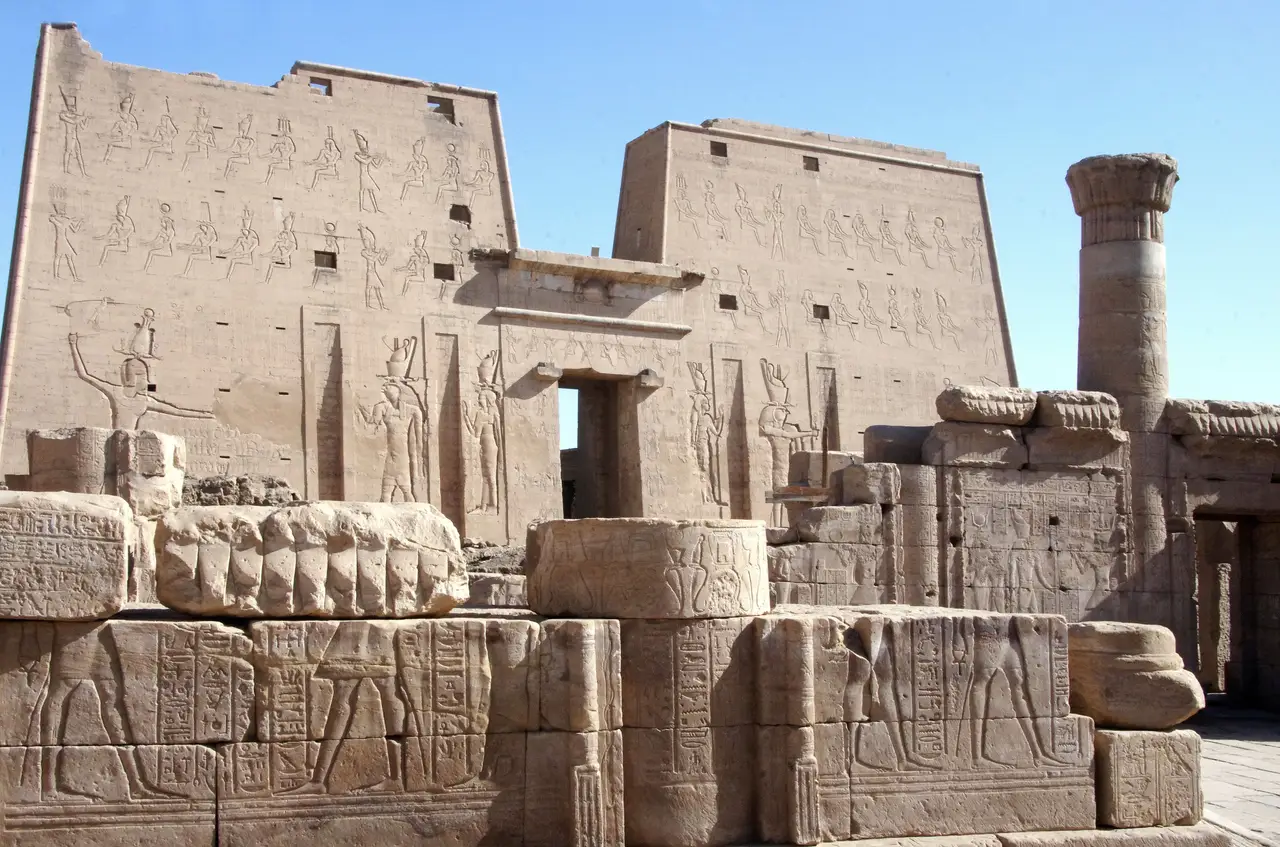 La façade massive du temple d'Edfou ornée de bas-reliefs représentant des divinités égyptiennes