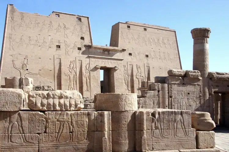 La façade massive du temple d'Edfou ornée de bas-reliefs représentant des divinités égyptiennes