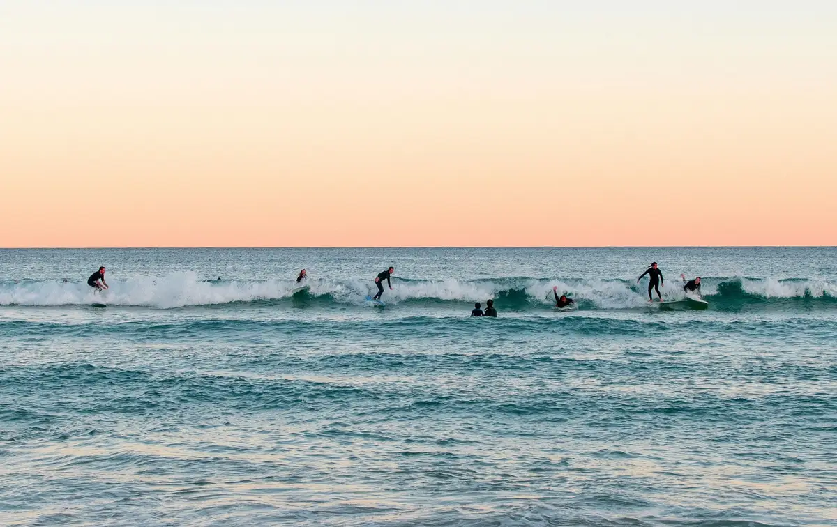 Surfeurs profitant des vagues à Bondi Beach au coucher du soleil
