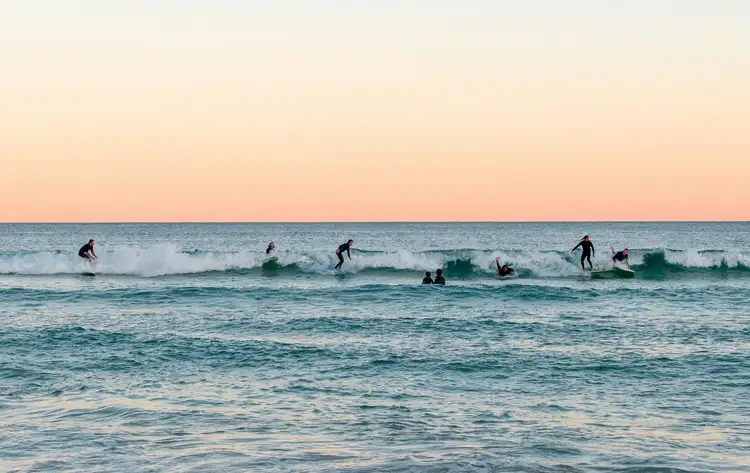 Surfeurs profitant des vagues à Bondi Beach au coucher du soleil