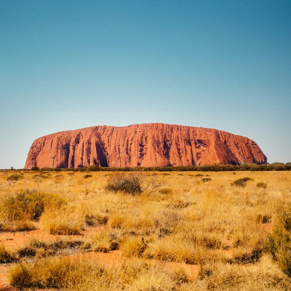 Panorama sauvage sur l'imposant monolithe rouge d'Uluru, symbole australien