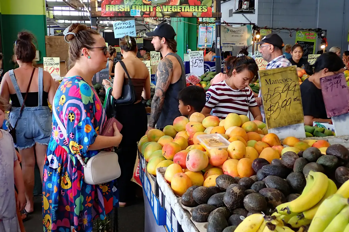 Étal de mangues et d'avocats frais au marché animé de Cairns
