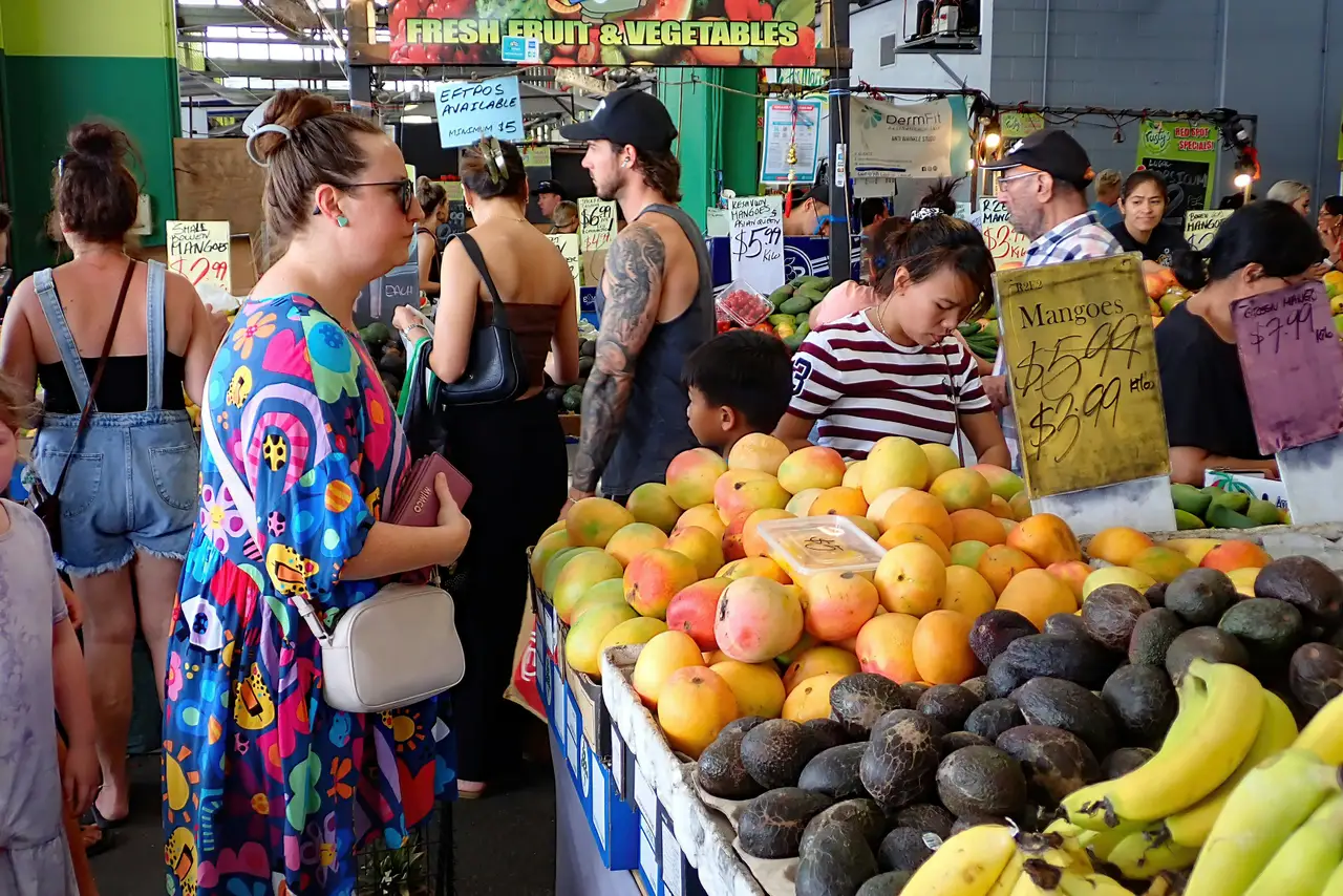 Étal de mangues et d'avocats frais au marché animé de Cairns