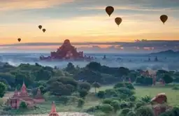 Travel in Asia - Hot air balloons rise above the ancient city of Bagan at sunset in Myanmar (Burma).