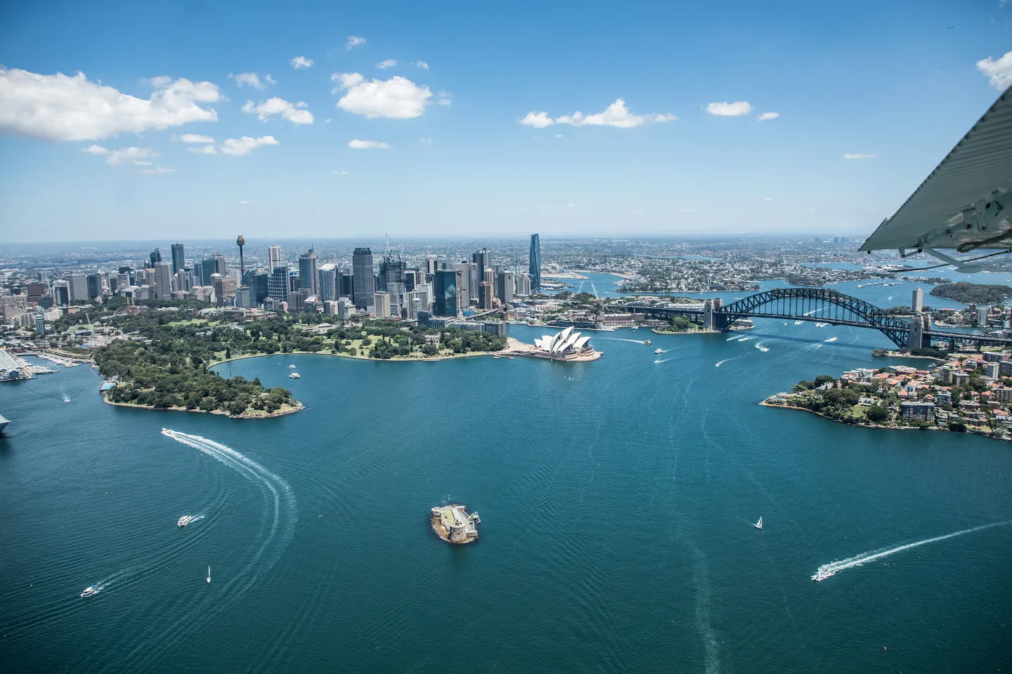 Vue aérienne spectaculaire de la baie de Sydney avec l'Opéra et le Harbour Bridge sous un ciel azur