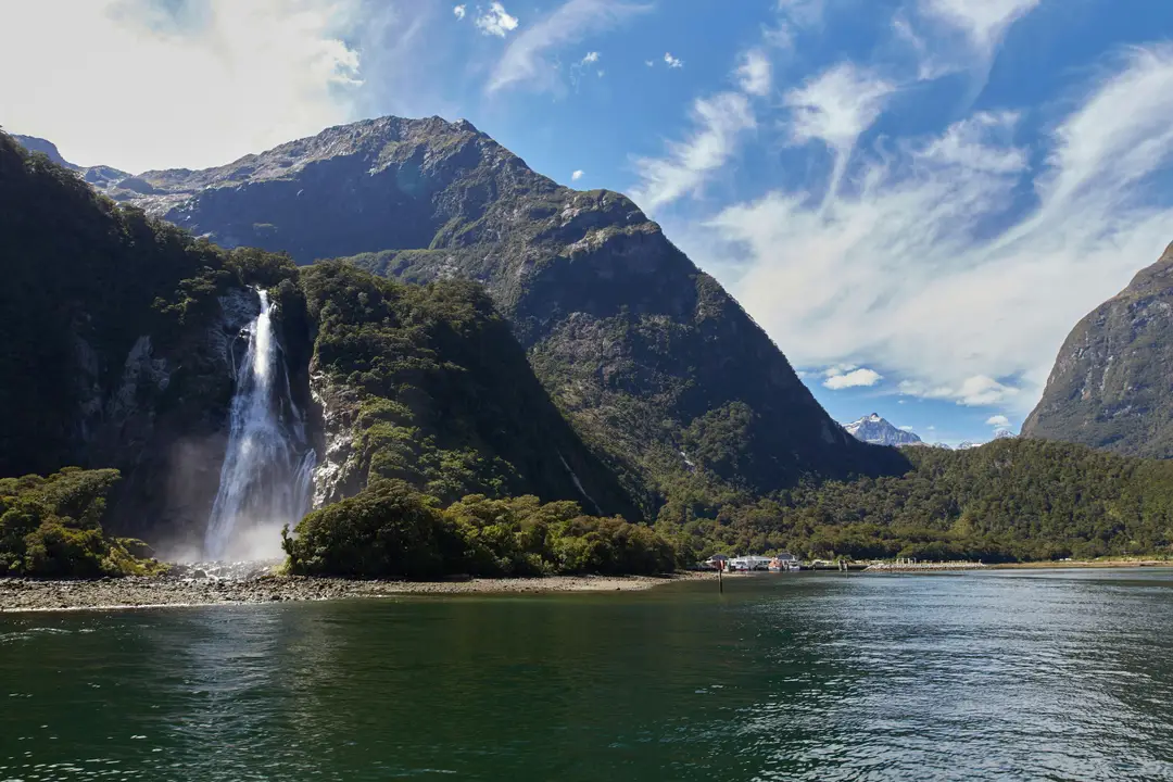 Majestueuse cascade se jetant dans les eaux du Milford Sound sous les montagnes de Nouvelle-Zélande.