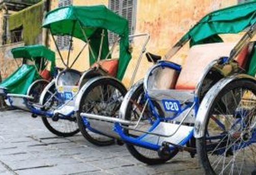Travel in Asia - Three rickshaws parked against a wall in Vietnam