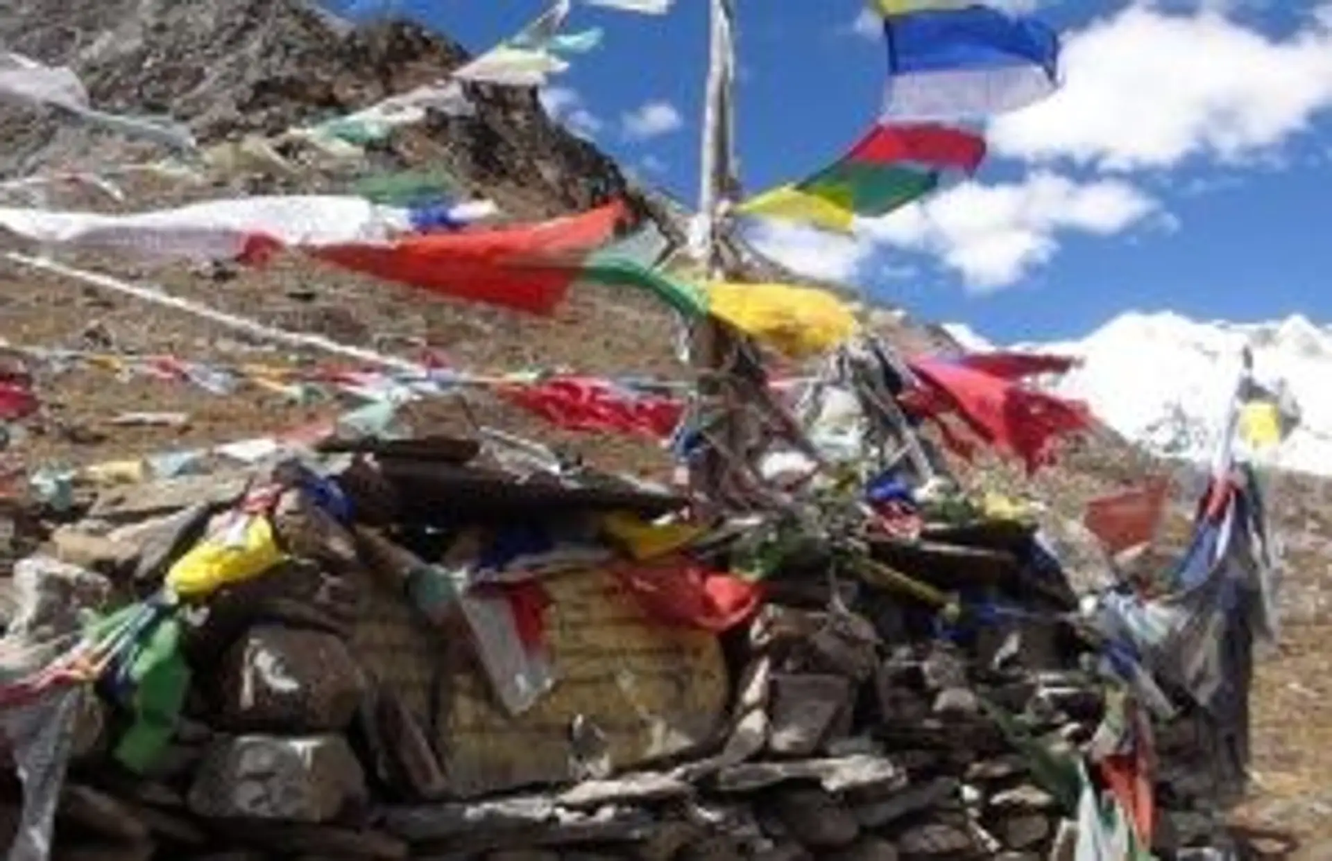 Drapeaux de prières bouddhistes colorés flottant sur un col de montagne lors d'un trek au Bhoutan