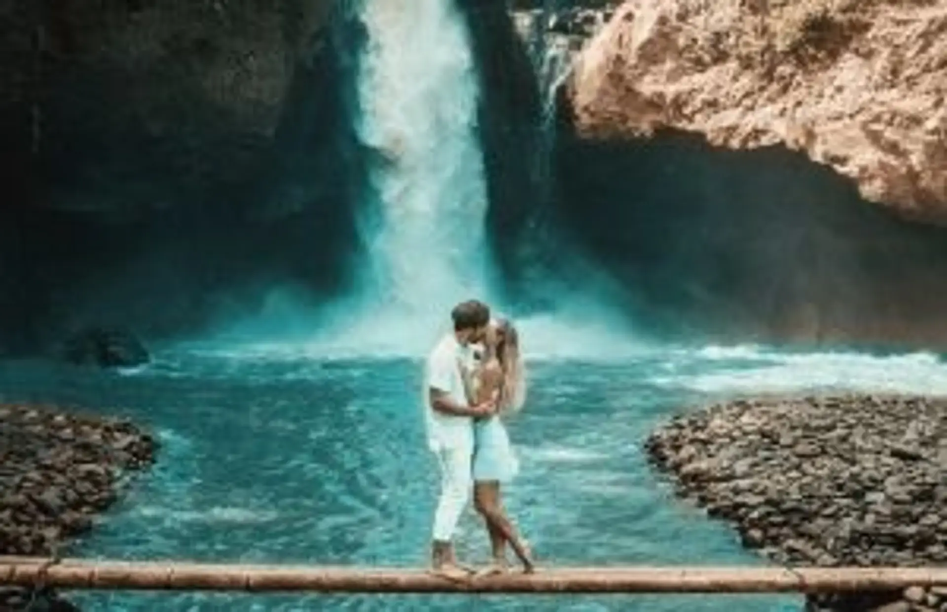 Couple de voyageurs devant une cascade naturelle au cœur de la jungle à Bali.