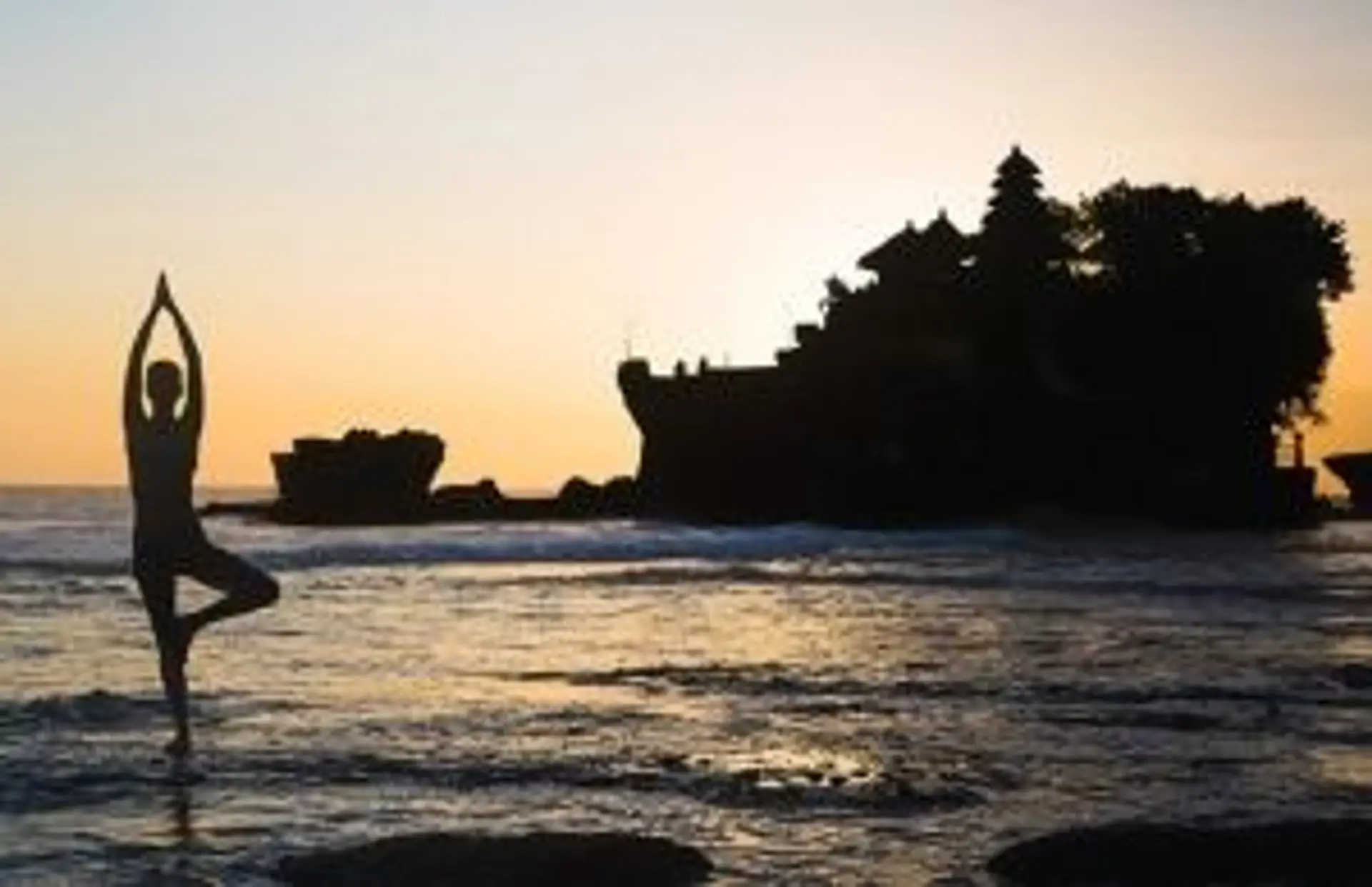 Voyage bien-être en Indonésie – Séance de yoga face à l'océan au coucher du soleil à Bali.
