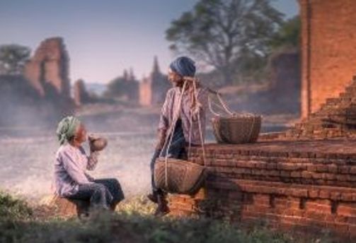 Travel in Asia - Two people talking amongst the stone walls of the ancient city of Bagan, Myanmar.
