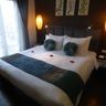 Travel in Asia - A king-sized bed adorned with decorative pillows and a runner in a modern hotel room