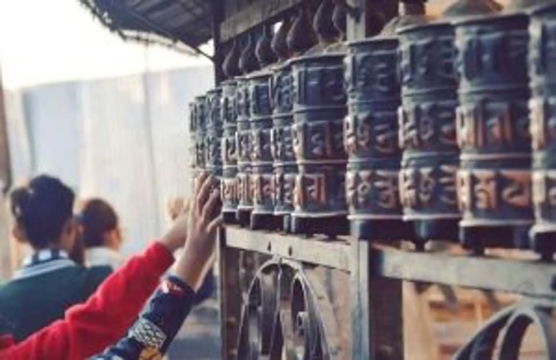 Voyage au Népal — Mains faisant tourner des moulins à prières bouddhistes traditionnels dans un temple de l'Himalaya.