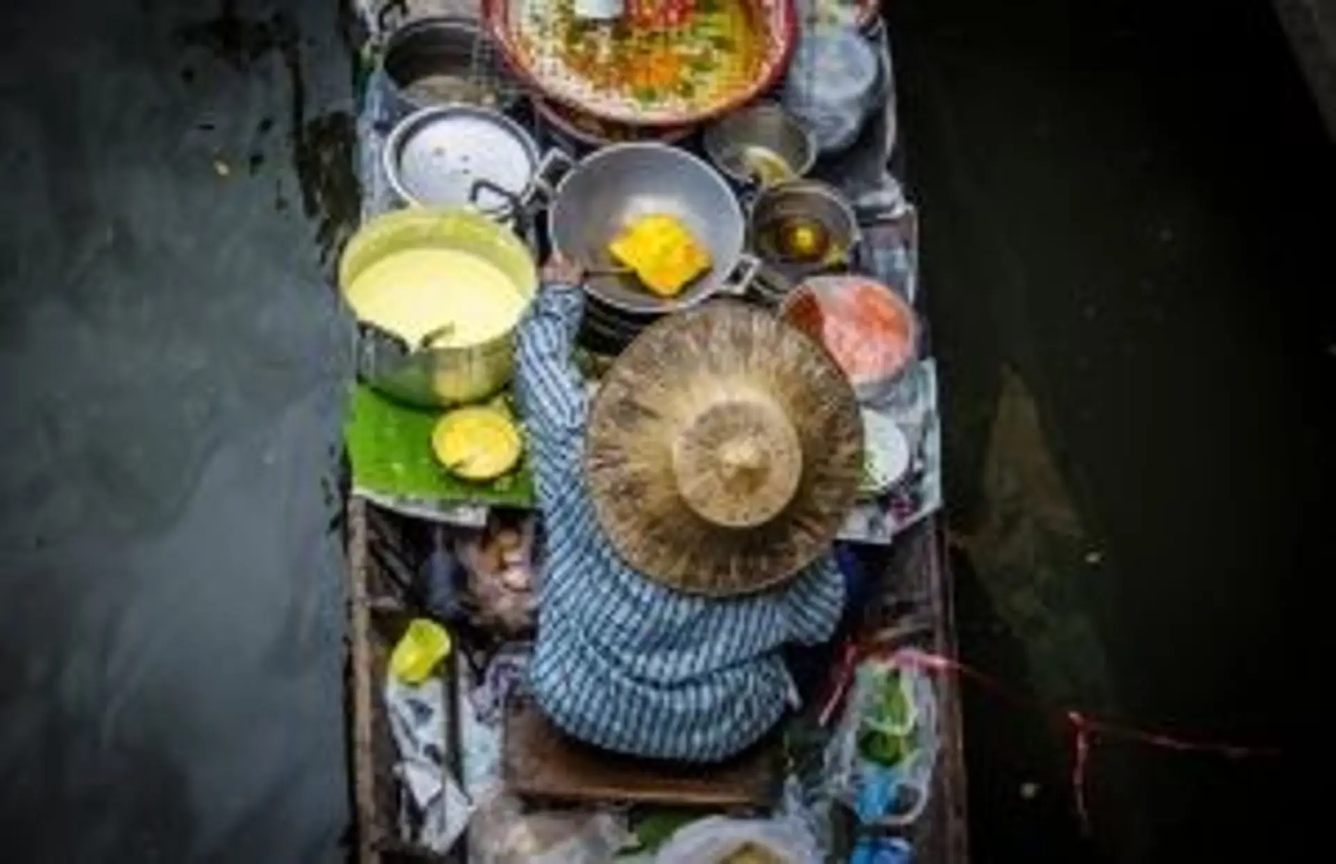Une marchande sur une barque de marché flottant traditionnel en Thaïlande
