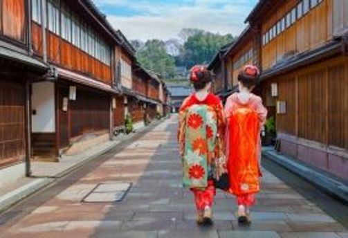 Travel in Asia - Two women wearing traditional kimono walking down a quiet street in the historic Higashi Chaya District of Kanazawa, Japan