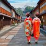 Travel in Asia - Two women wearing traditional kimono walking down a quiet street in the historic Higashi Chaya District of Kanazawa, Japan