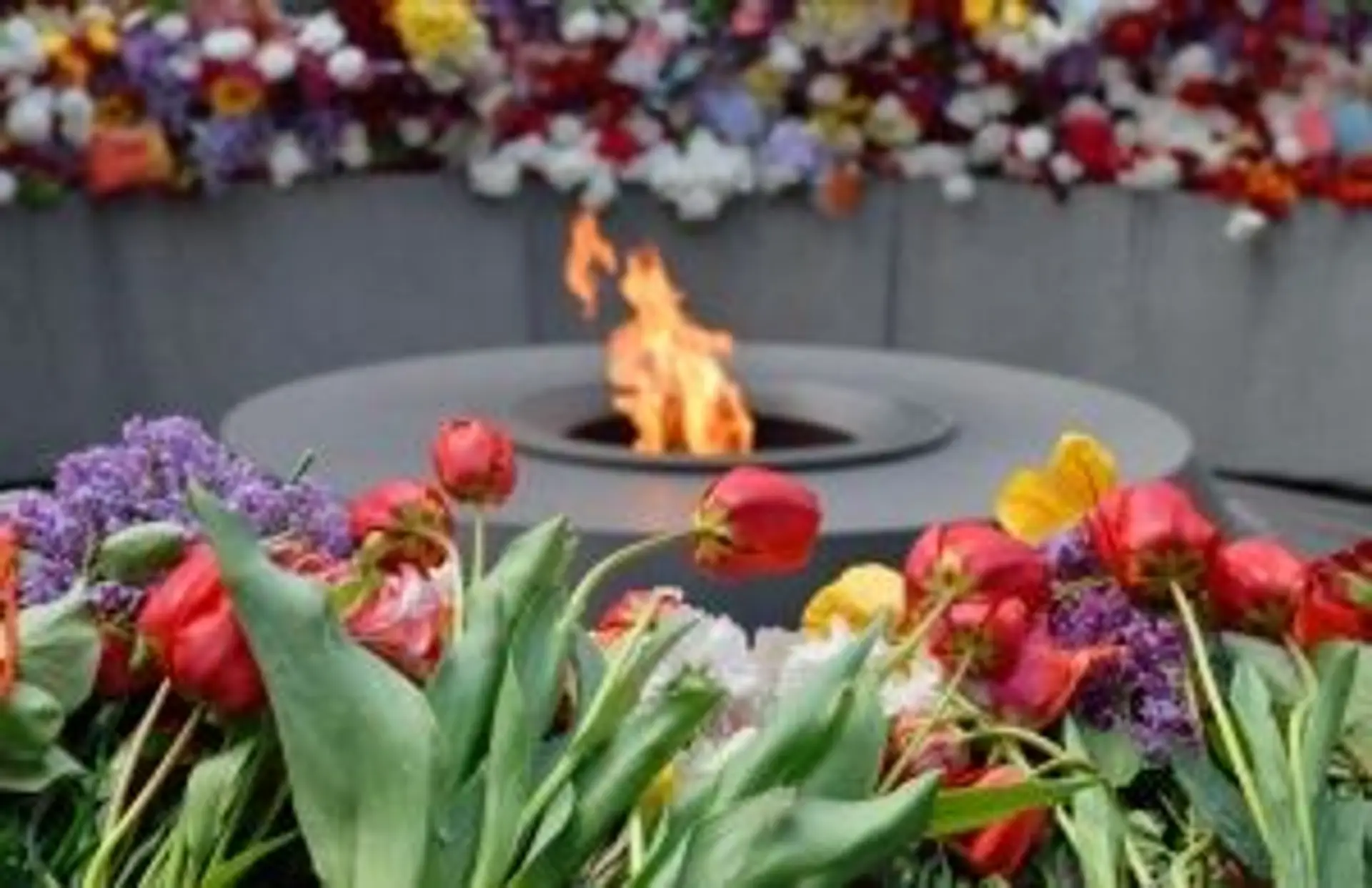 Flamme éternelle entourée de fleurs au Mémorial du génocide arménien à Erevan