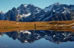 Voyage en Géorgie — Sommets enneigés du Grand Caucase se reflétant dans les eaux calmes d'un lac d'altitude.
