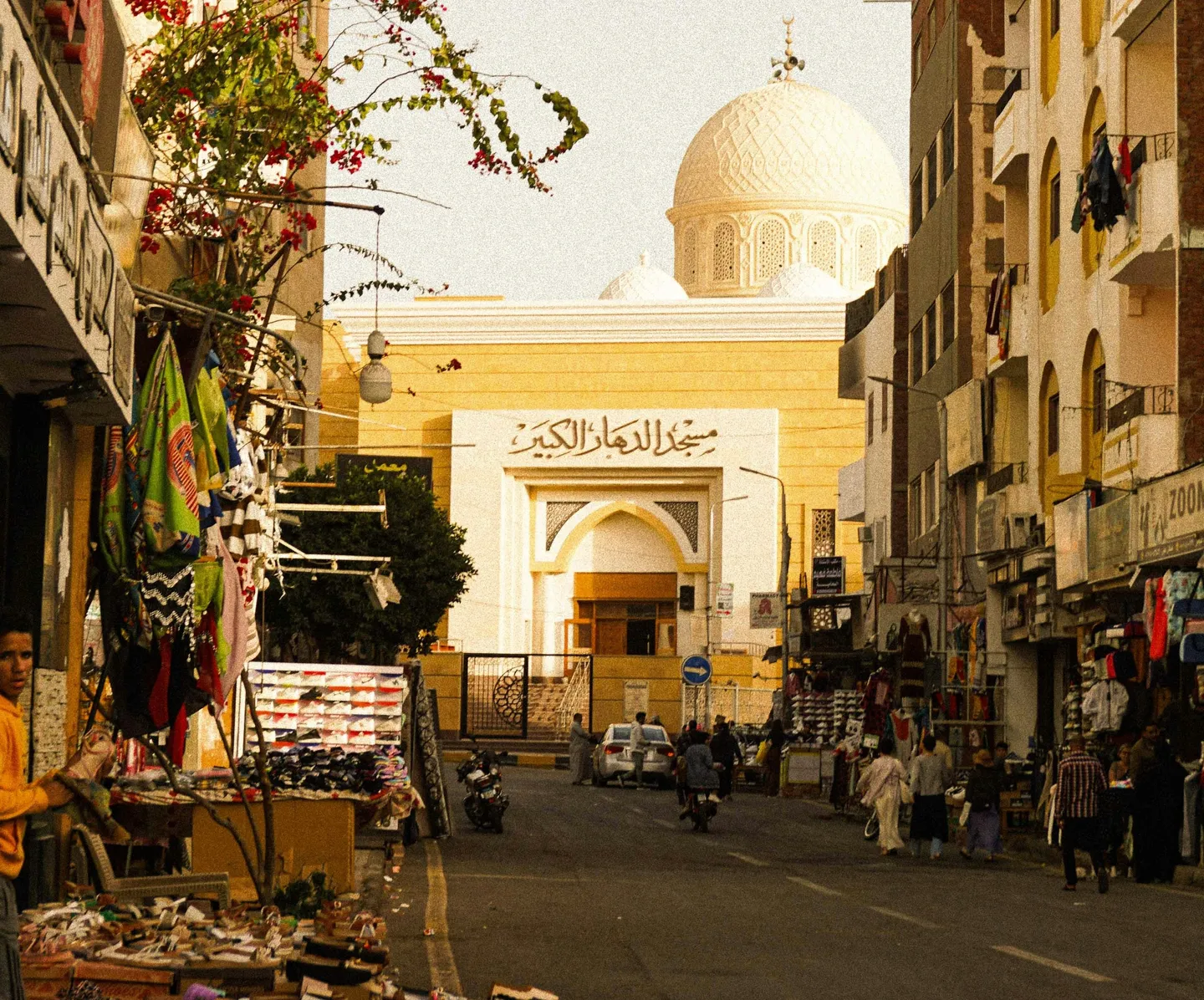 Voyage en Asie – rue animée menant vers une grande mosquée blanche en Égypte