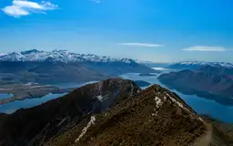 Vue panoramique depuis un sentier de crête sur un lac et des montagnes enneigées en Nouvelle-Zélande.