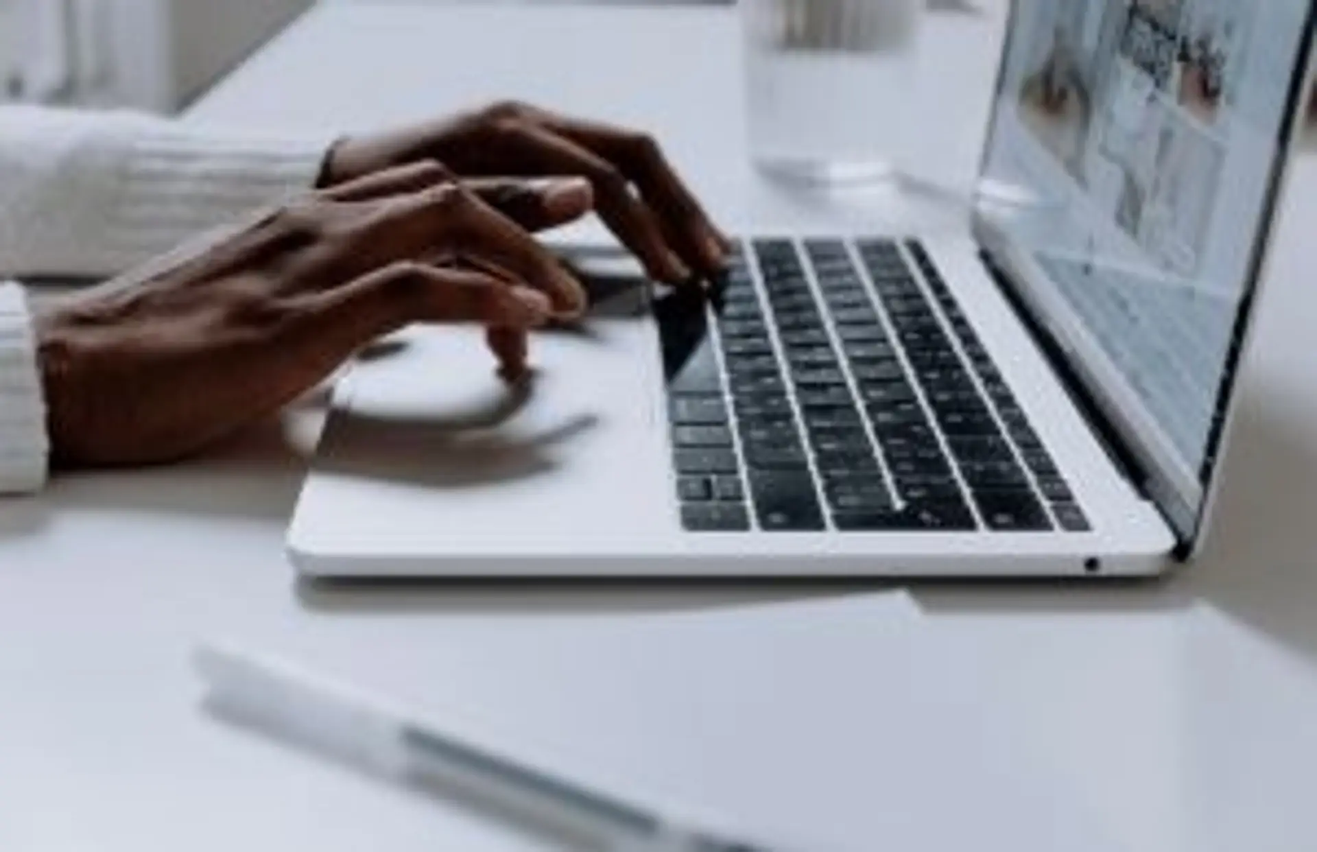 Mains d'un voyageur sur un ordinateur préparant son itinéraire pour un voyage à Bali.