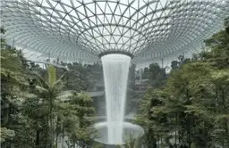 Cascade intérieure géante Rain Vortex entourée d'une forêt tropicale au Jewel Changi Airport de Singapour