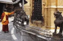 Voyage au Bhoutan — Moine bouddhiste faisant tourner des moulins à prières dans un temple, symbole de la sérénité bhoutanaise.