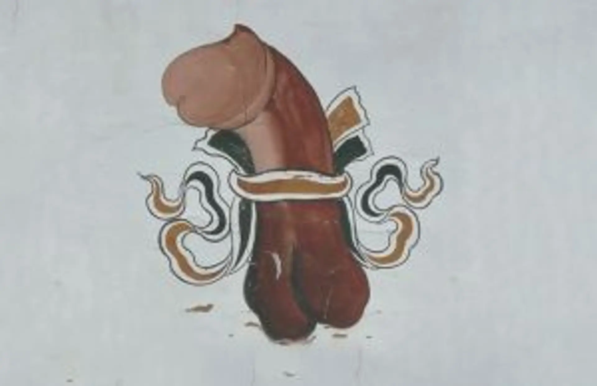 Alignement de moulins à prières en métal devant un mur de pierres au Bhoutan