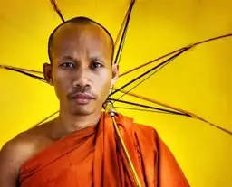 Moine bouddhiste cambodgien avec une ombrelle jaune traditionnelle illustrant la spiritualité au Cambodge